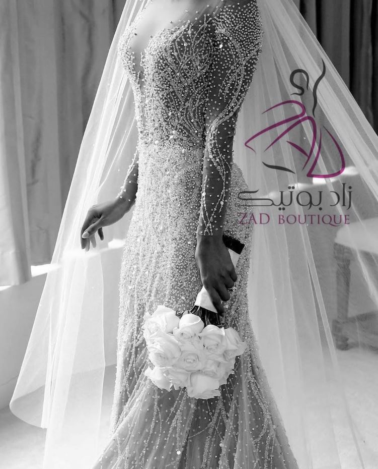 Bride in a beaded veil and gown holding a bouquet, Zad Style